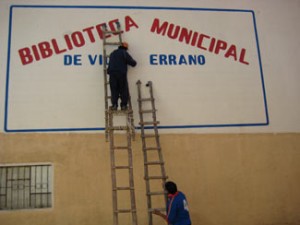 1villaserrano.ladder Putting the final touches on the exterior library sign.